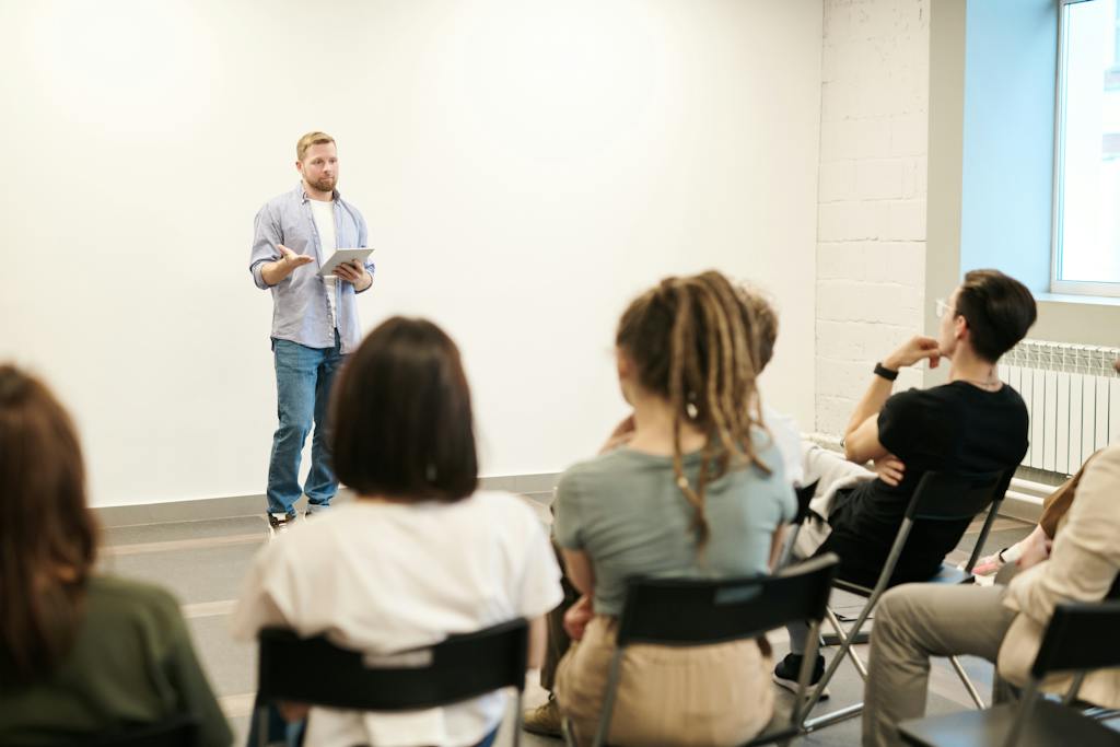 Man Wearing Gray Dress Shirt and Blue Jeans at one of his local coworking events.