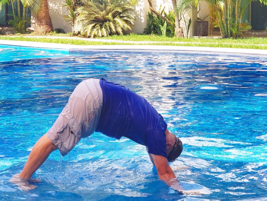 David doing pool yoga on a remote work lunch break in Mexico