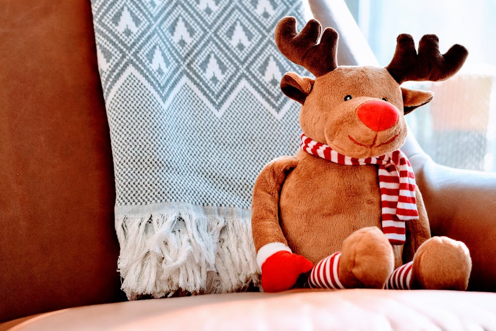 Adorable stuffed reindeer toy on a leather chair, creating a warm, festive atmosphere.